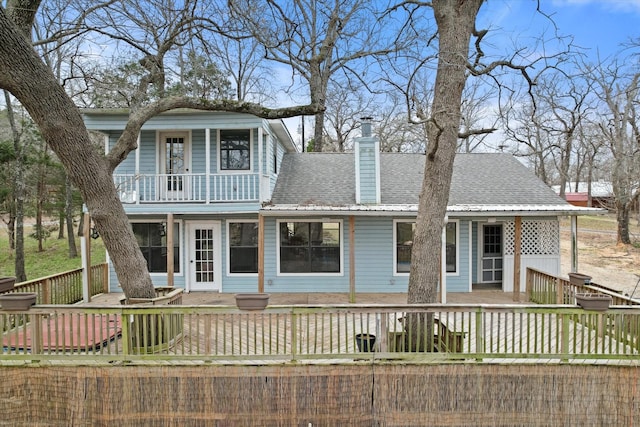 149 Lakeview Dr, Streetman, TX 75859 - view of front of home with a balcony, a chimney, a shingled roof, and a deck