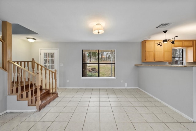 interior space with light tile patterned floors, baseboards, stairs, and visible vents