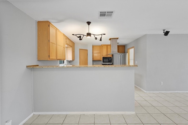 kitchen with black microwave, a peninsula, visible vents, freestanding refrigerator, and island exhaust hood