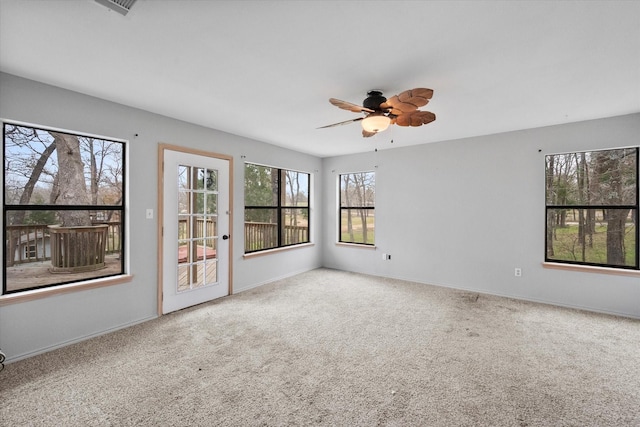 carpeted spare room with ceiling fan and baseboards