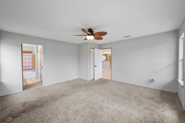 unfurnished bedroom with a ceiling fan, carpet flooring, connected bathroom, and visible vents