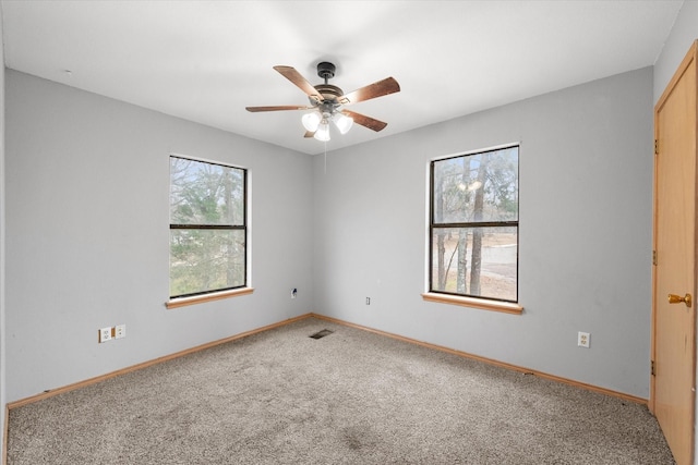 spare room with baseboards, visible vents, ceiling fan, and carpet flooring