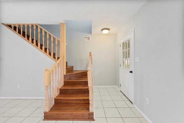 stairway featuring tile patterned flooring, visible vents, and baseboards