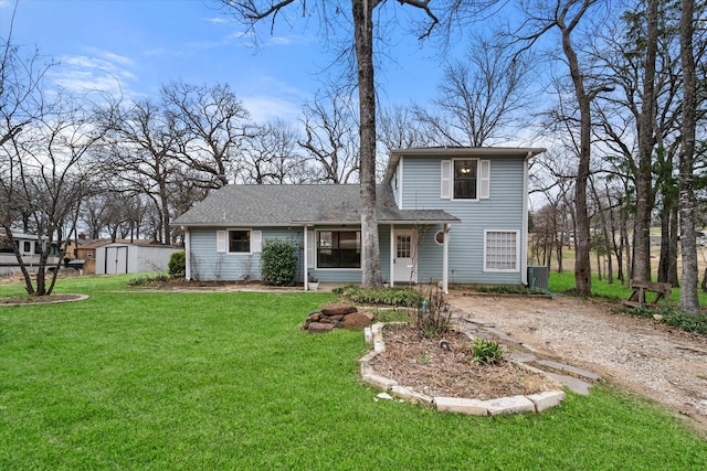 149 Lakeview Dr, Streetman, TX 75859 - view of front of property featuring a front yard, a storage unit, driveway, a shingled roof, and an outdoor structure