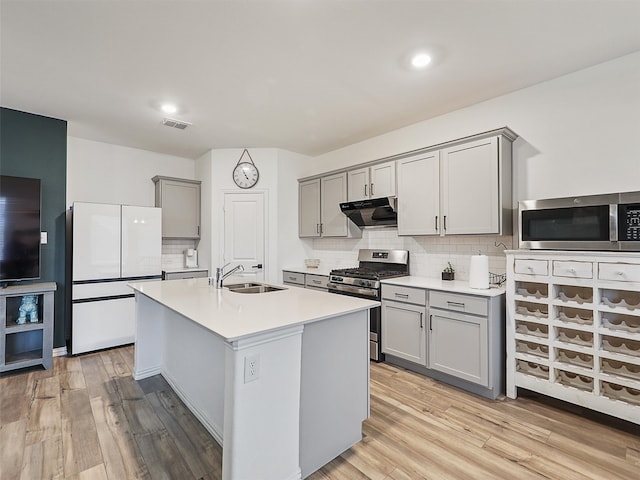 kitchen with stainless steel appliances, gray cabinets, visible vents, a sink, and under cabinet range hood