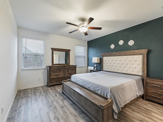 bedroom with wood finished floors, a ceiling fan, and baseboards