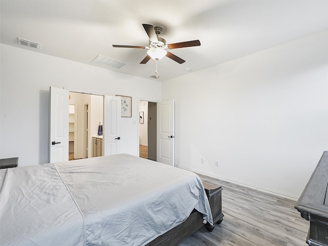 bedroom featuring baseboards, visible vents, ceiling fan, and wood finished floors