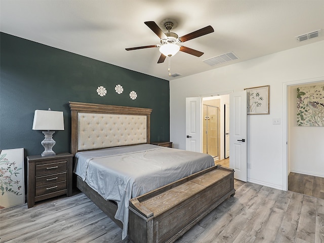 bedroom featuring wood finished floors, visible vents, and baseboards