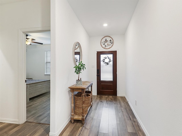 doorway with wood finished floors and baseboards