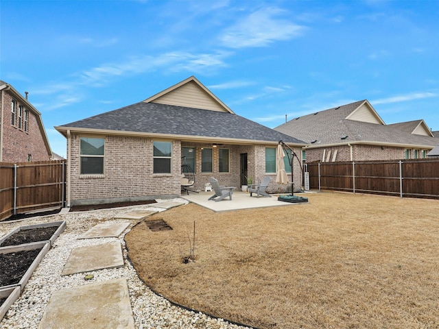 back of house featuring brick siding, a fenced backyard, a vegetable garden, and a patio