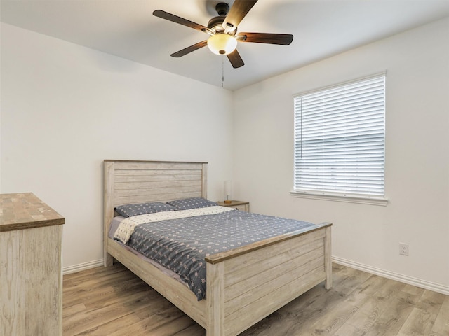 bedroom with wood finished floors, a ceiling fan, and baseboards