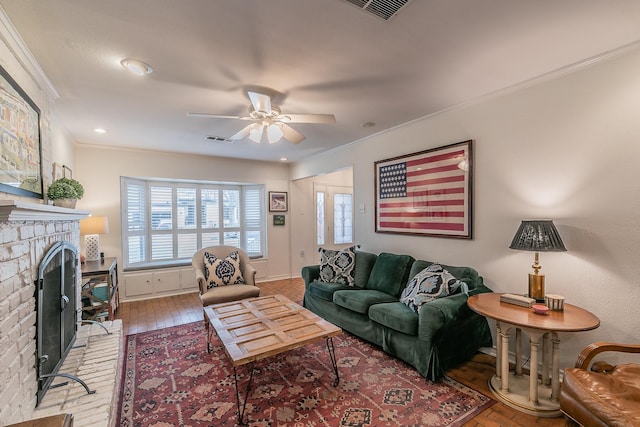 living room featuring crown molding, a fireplace, visible vents, and a healthy amount of sunlight