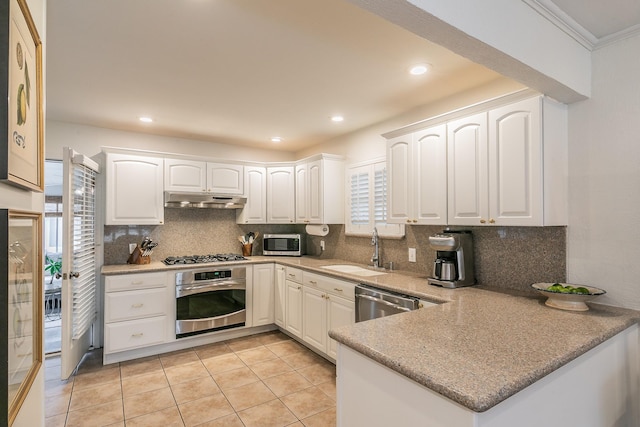 kitchen featuring appliances with stainless steel finishes, a sink, white cabinetry, and under cabinet range hood