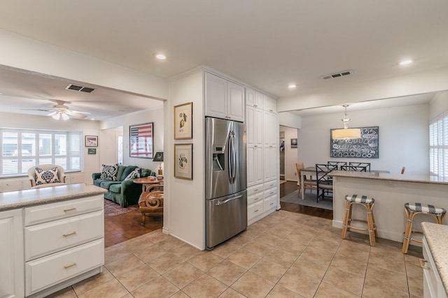 kitchen with a healthy amount of sunlight, visible vents, stainless steel refrigerator with ice dispenser, and light tile patterned flooring