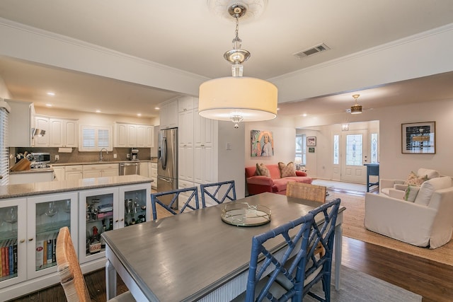 dining space featuring ornamental molding, visible vents, and dark wood-type flooring