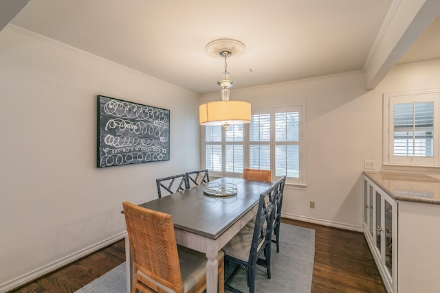 dining room with baseboards, dark wood finished floors, and crown molding