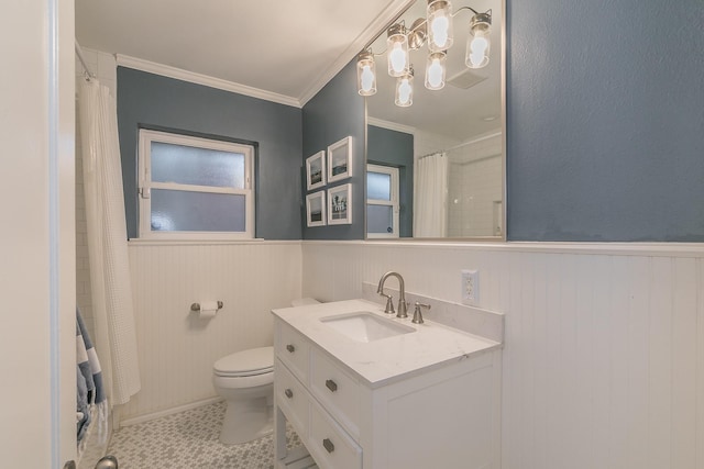 bathroom featuring ornamental molding, wainscoting, vanity, and toilet