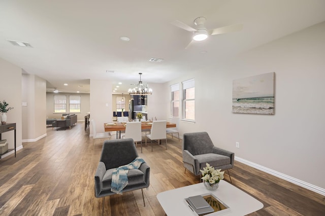 living area featuring hardwood / wood-style flooring, visible vents, and baseboards