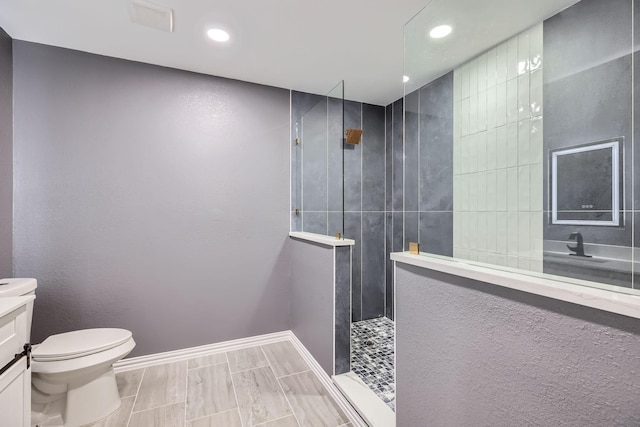 full bathroom with baseboards, toilet, vanity, a walk in shower, and recessed lighting