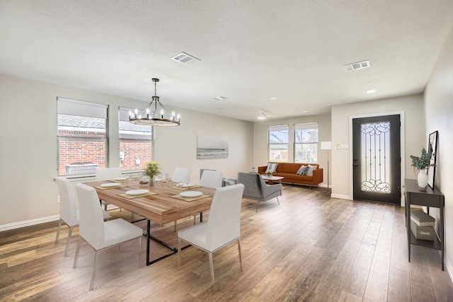 dining space featuring hardwood / wood-style flooring, baseboards, and visible vents