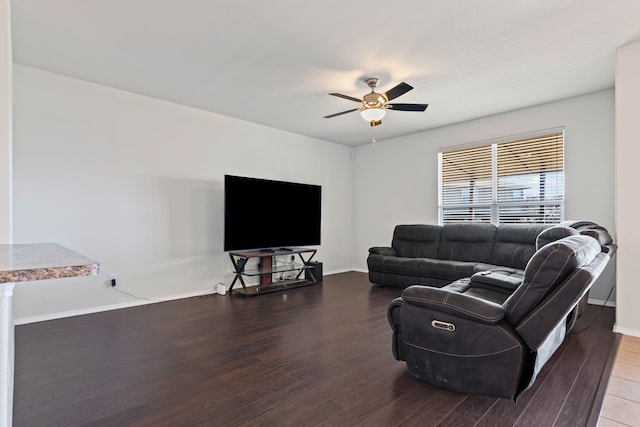 living area with baseboards, a ceiling fan, and wood finished floors