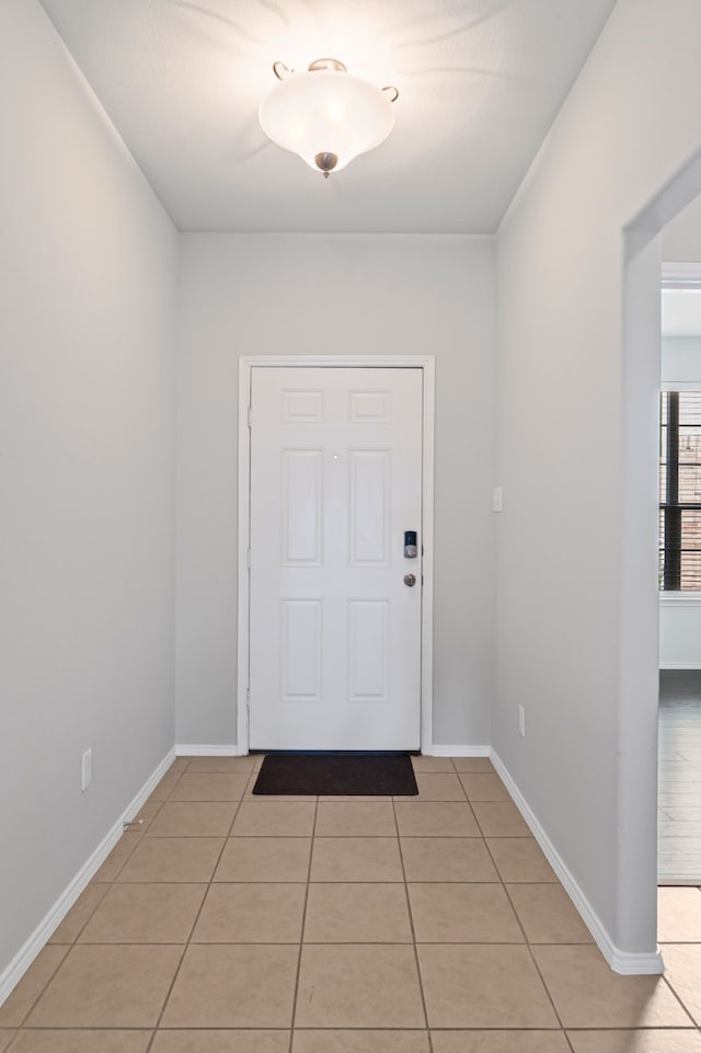 doorway to outside with light tile patterned floors and baseboards