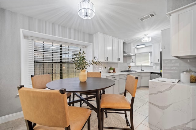 kitchen featuring appliances with stainless steel finishes, visible vents, decorative backsplash, and light tile patterned flooring