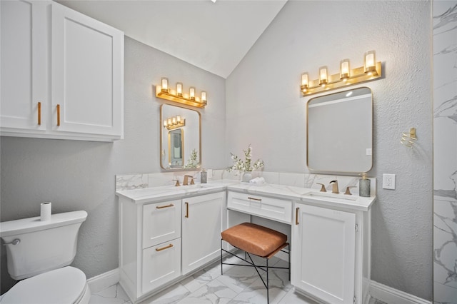 bathroom featuring lofted ceiling, marble finish floor, a sink, and toilet