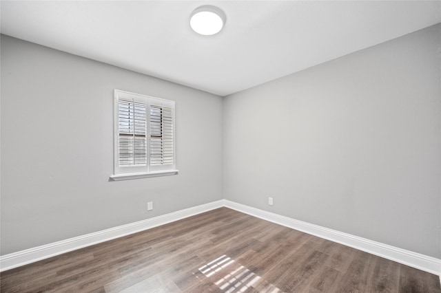 spare room featuring wood finished floors and baseboards