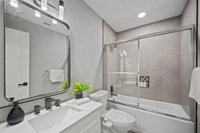 full bathroom featuring visible vents, enclosed tub / shower combo, vanity, and toilet