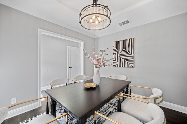 dining space with baseboards, dark wood-type flooring, visible vents, and an inviting chandelier