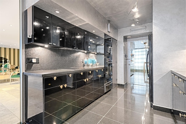 kitchen with stainless steel counters, visible vents, granite finish floor, dark cabinets, and black appliances