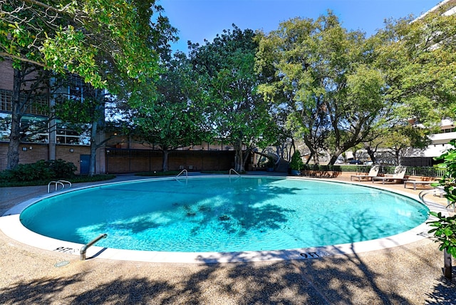 community pool featuring a patio area and fence