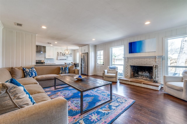 living area featuring recessed lighting, visible vents, dark wood finished floors, and a fireplace