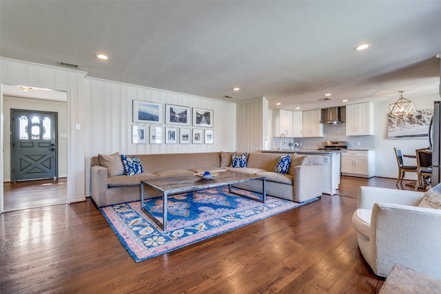 living area with recessed lighting, visible vents, and dark wood finished floors