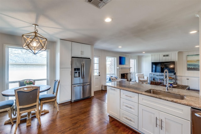 kitchen with dark wood-style floors, a fireplace, stainless steel appliances, visible vents, and a sink