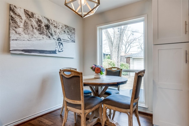 dining area with dark wood-style floors, baseboards, and a notable chandelier