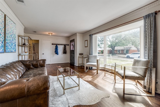 living room with visible vents, ornamental molding, and wood finished floors