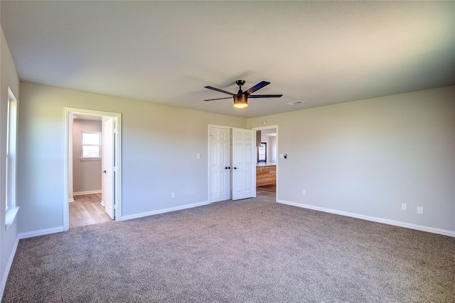 unfurnished bedroom with carpet floors, visible vents, baseboards, and connected bathroom