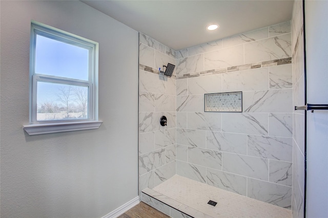 full bath featuring tiled shower, recessed lighting, wood finished floors, and baseboards