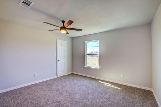 spare room featuring carpet floors, baseboards, visible vents, and ceiling fan