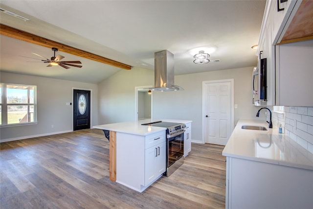 kitchen featuring island range hood, a sink, open floor plan, electric stove, and backsplash