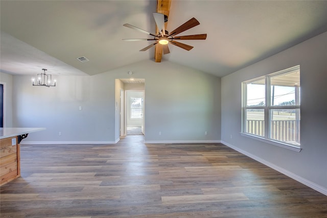 unfurnished living room with baseboards, visible vents, lofted ceiling with beams, wood finished floors, and ceiling fan with notable chandelier