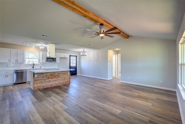 kitchen featuring visible vents, decorative backsplash, island range hood, stainless steel appliances, and white cabinetry