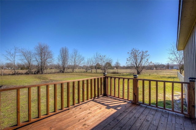 wooden terrace featuring a rural view and a yard