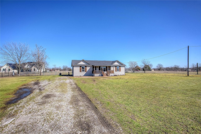 view of front of house featuring driveway, a front lawn, a porch, and fence