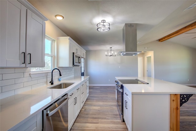 kitchen featuring decorative backsplash, appliances with stainless steel finishes, a sink, island range hood, and light wood-type flooring