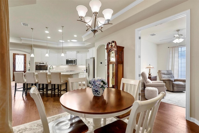 dining room with hardwood / wood-style flooring, visible vents, and crown molding