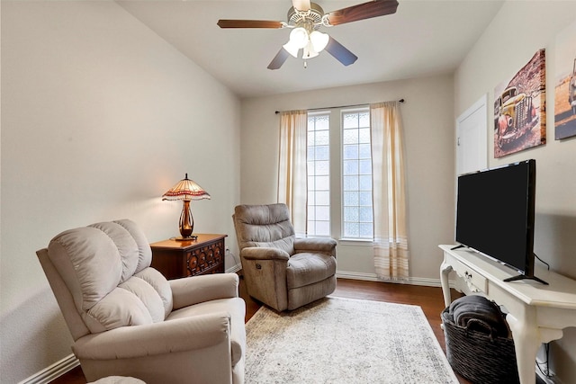 sitting room with dark wood-style floors, baseboards, and a ceiling fan