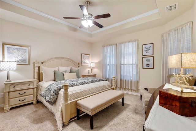 bedroom featuring light colored carpet, a raised ceiling, visible vents, and crown molding